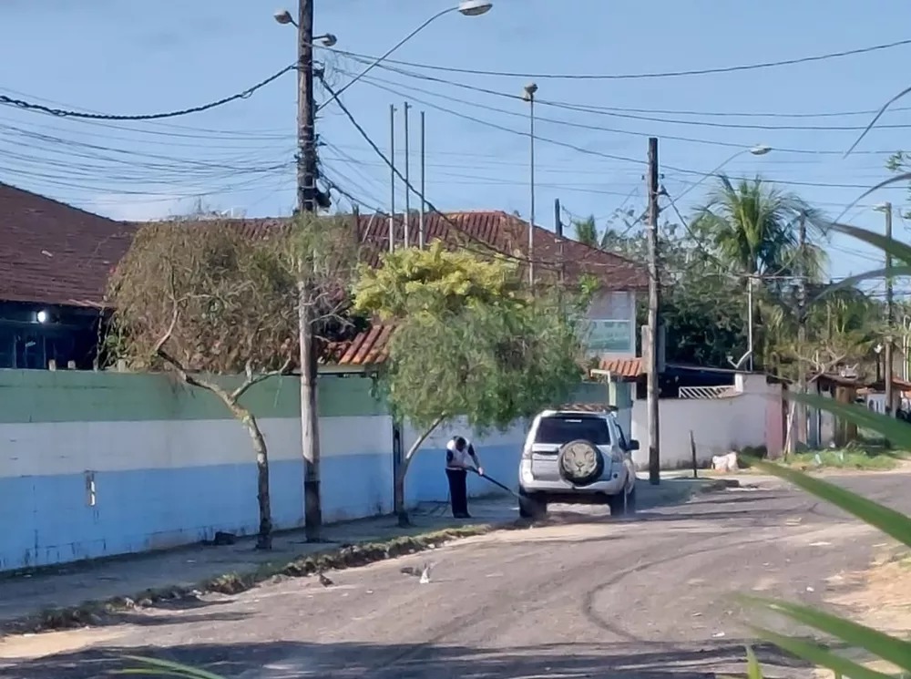 Funcionária de escola lava carro na calçada da unidade em Bertioga